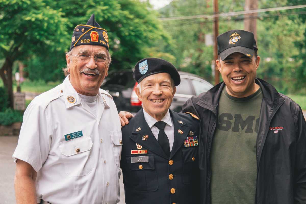 three elderly veterans standing together
